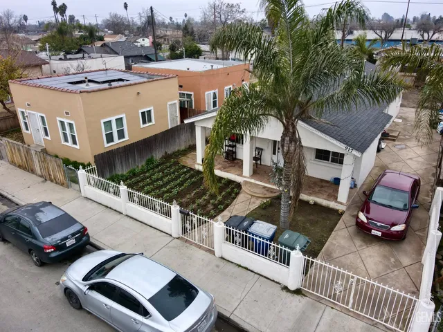 a living room with furniture a chandelier and a dining table with wooden floor