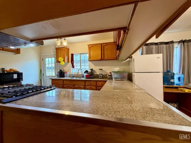 a kitchen with wooden cabinets and a stove top oven