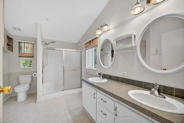 a bathroom with a granite countertop sink a toilet and shower