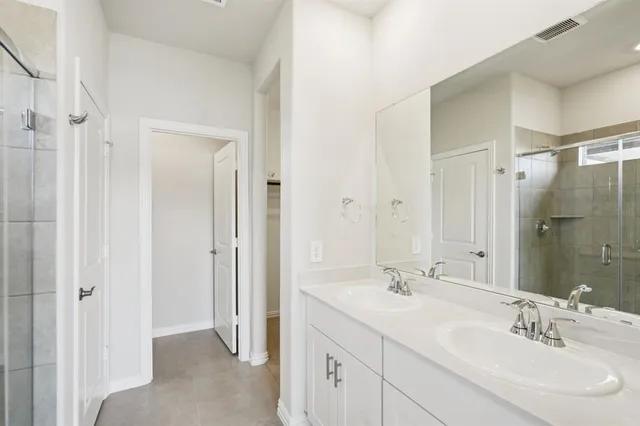 a bathroom with a double vanity sink mirror and shower