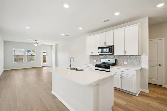 a kitchen with stainless steel appliances a sink stove and cabinets