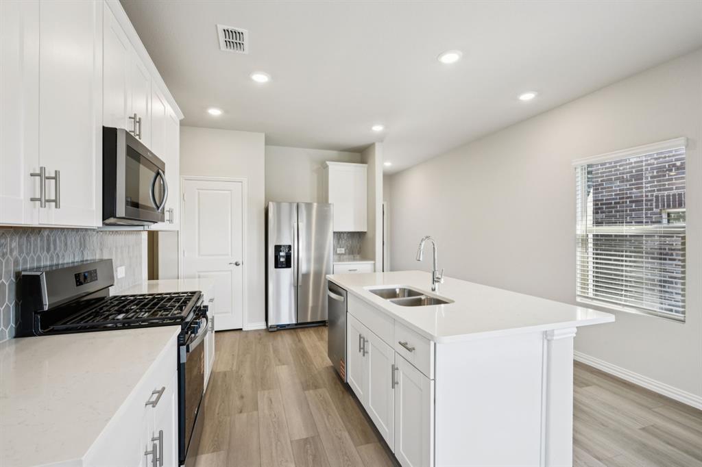 1632 Arches Road Anna, TX 75409 - Photo 5 of 29 a kitchen that has a sink a stove and a refrigerator