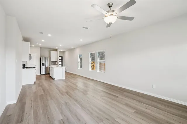 a view of a kitchen with wooden floor and a ceiling fan