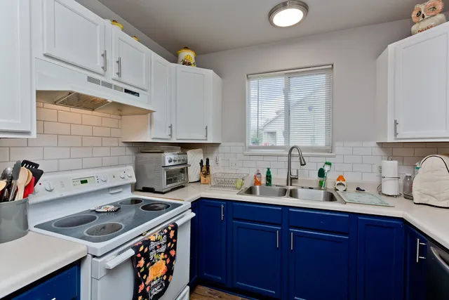 a kitchen with stainless steel appliances a stove a sink dishwasher and cabinets with wooden floor