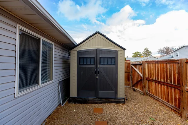a view of a patio with table and chairs and wooden fence