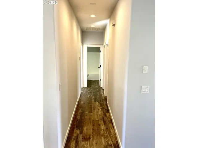 a view of a room with wooden floor and a window