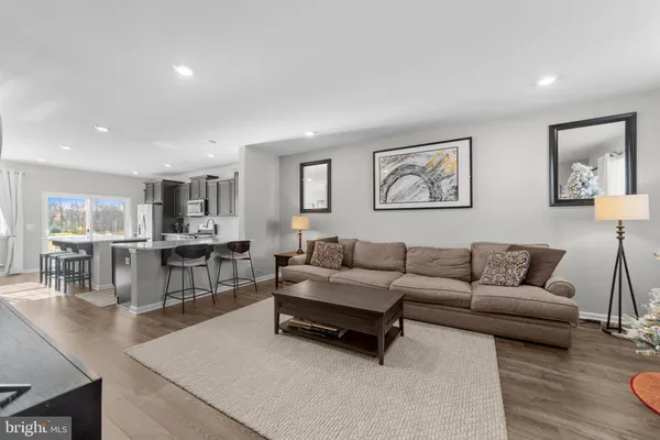 a living room with furniture and view of kitchen