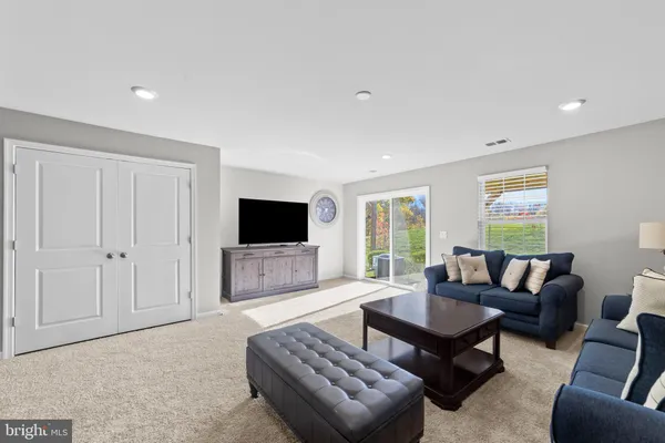 a living room with furniture a flat screen tv and a window