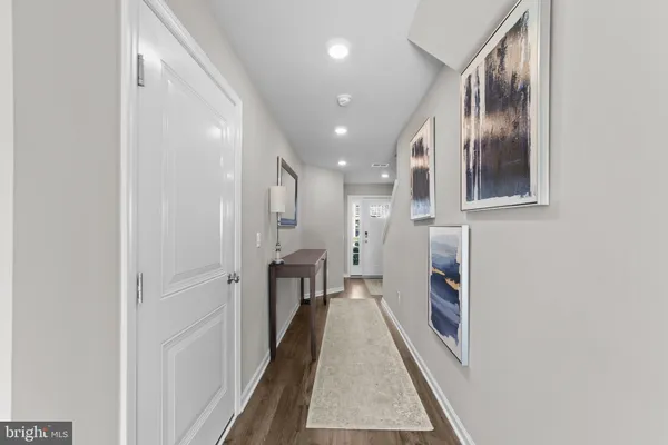 a hallway with a white kitchen