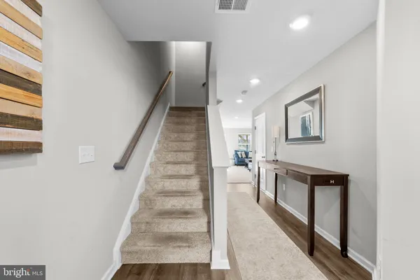 a view of a hallway with wooden floor and staircase