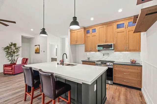 a kitchen with stainless steel appliances a stove a sink a microwave a refrigerator and cabinets