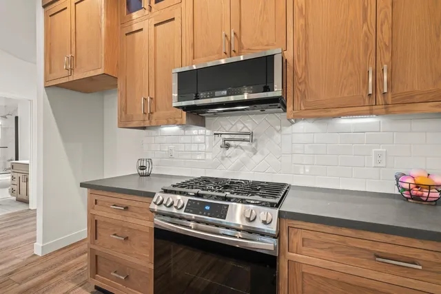 a kitchen with stainless steel appliances a stove a microwave and cabinets