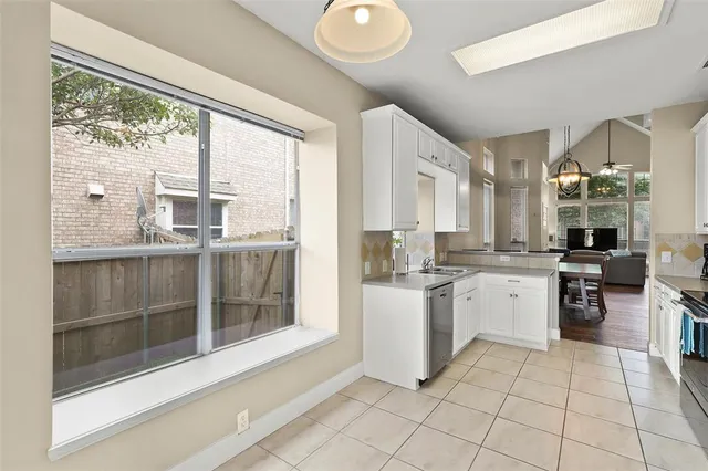 a large white kitchen with a large window
