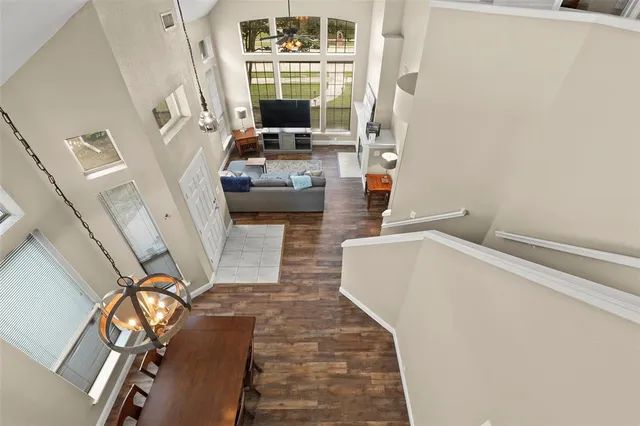 a living room with furniture floor to ceiling window and a flat screen tv