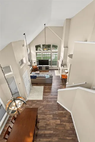 a living room with couches a fireplace and a chandelier