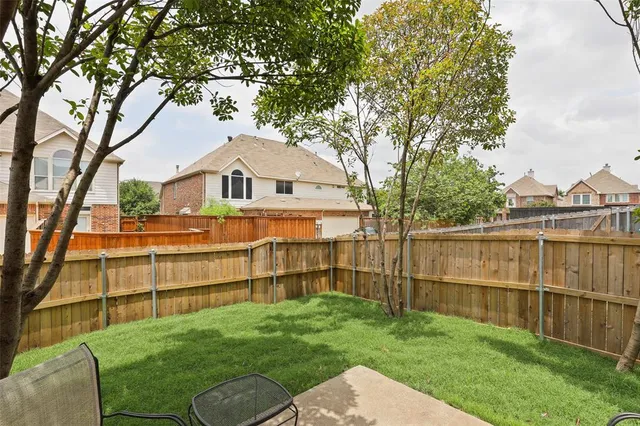 a view of a white house with a big yard and large tree