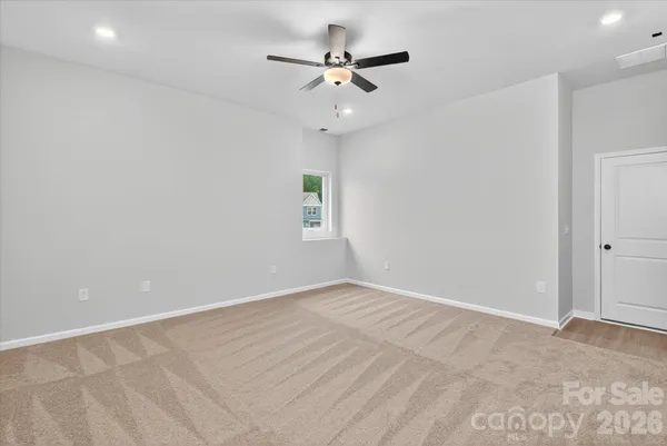 a view of an empty room with a ceiling fan