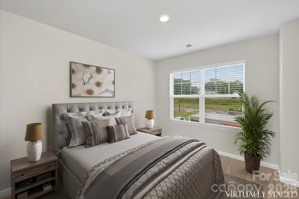 a bedroom with a large bed and a potted plant