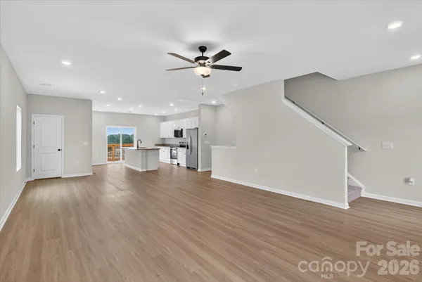 a view of a livingroom with wooden floor and a ceiling fan