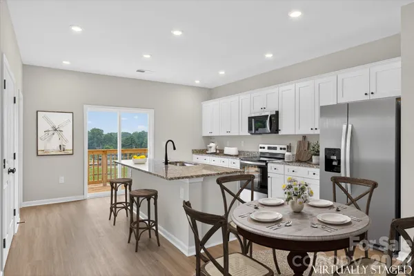 a kitchen with stainless steel appliances a dining table and chairs