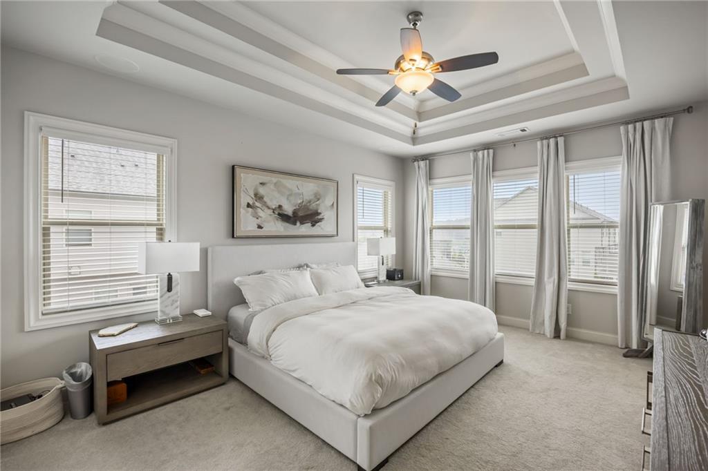 1799 Falling Sky Court Atlanta, GA 30319 - Photo 11 of 26 a bedroom with a bed a ceiling fan and a large window