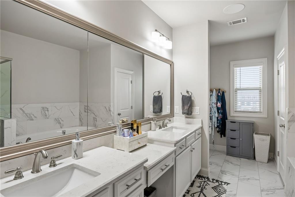 1799 Falling Sky Court Atlanta, GA 30319 - Photo 15 of 26 a bathroom with double vanity sink a mirror and a shower