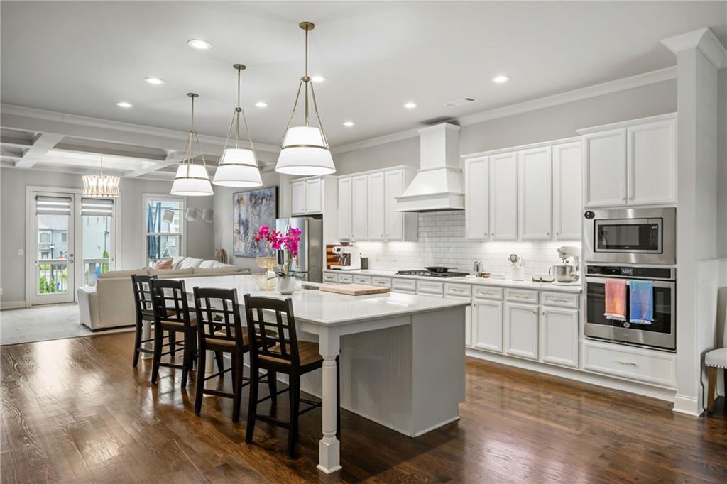 1799 Falling Sky Court Atlanta, GA 30319 - Photo 2 of 26 a kitchen with kitchen island granite countertop a table and chairs in it