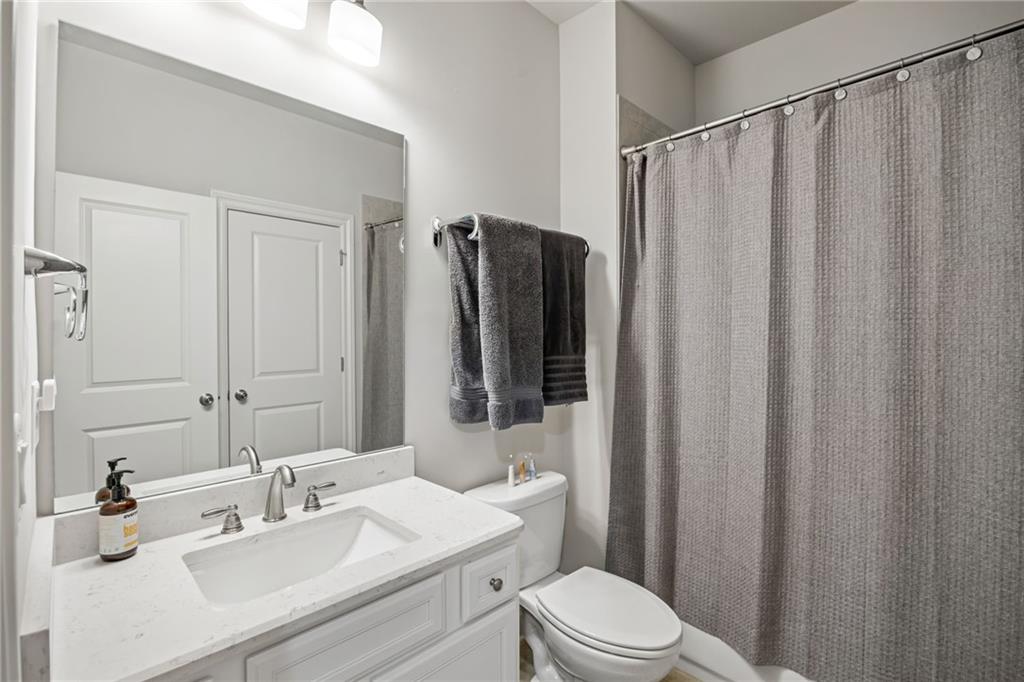 1799 Falling Sky Court Atlanta, GA 30319 - Photo 26 of 26 a bathroom with a sink a toilet a mirror and shower curtain