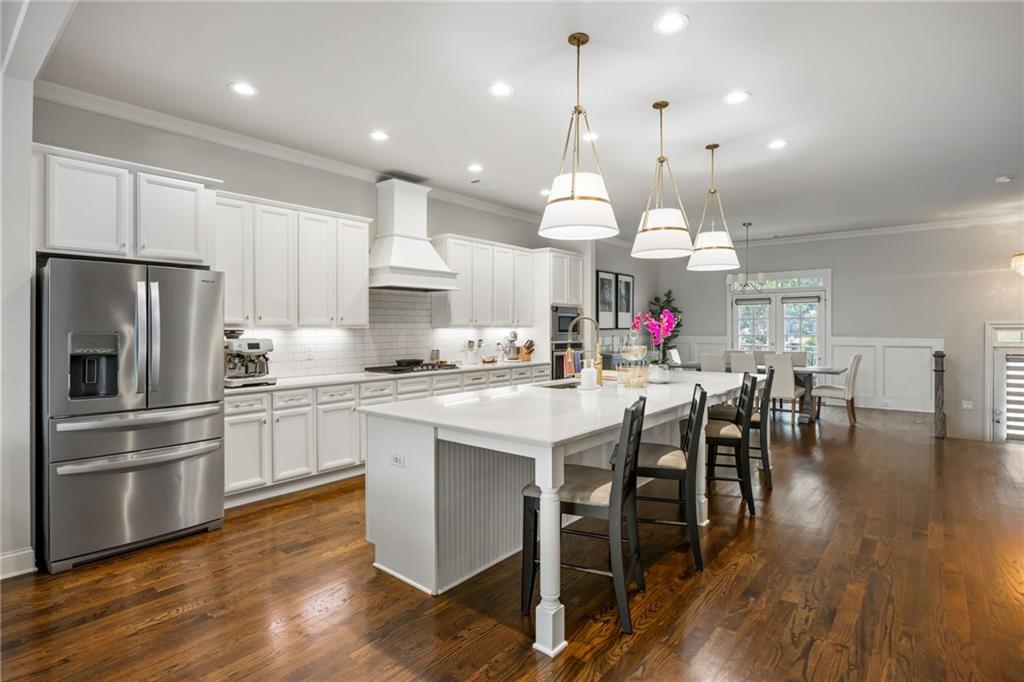 1799 Falling Sky Court Atlanta, GA 30319 - Photo 4 of 26 a kitchen with stainless steel appliances a dining table chairs stove refrigerator and cabinets