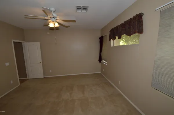 an empty room with windows and fan