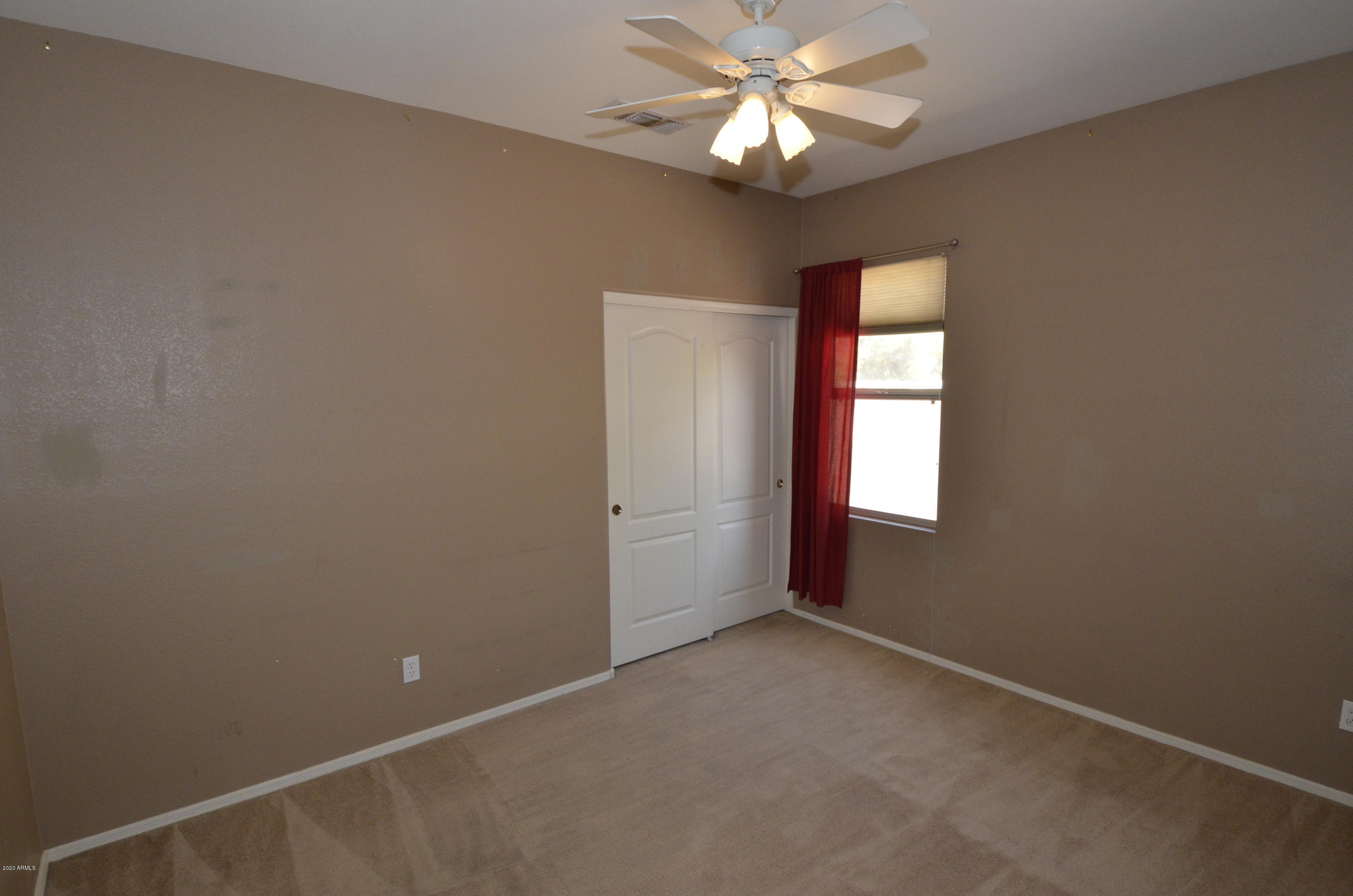 1148 South Roca Street Gilbert, AZ 85296 - Photo 18 of 20 an empty room with a window and a fan