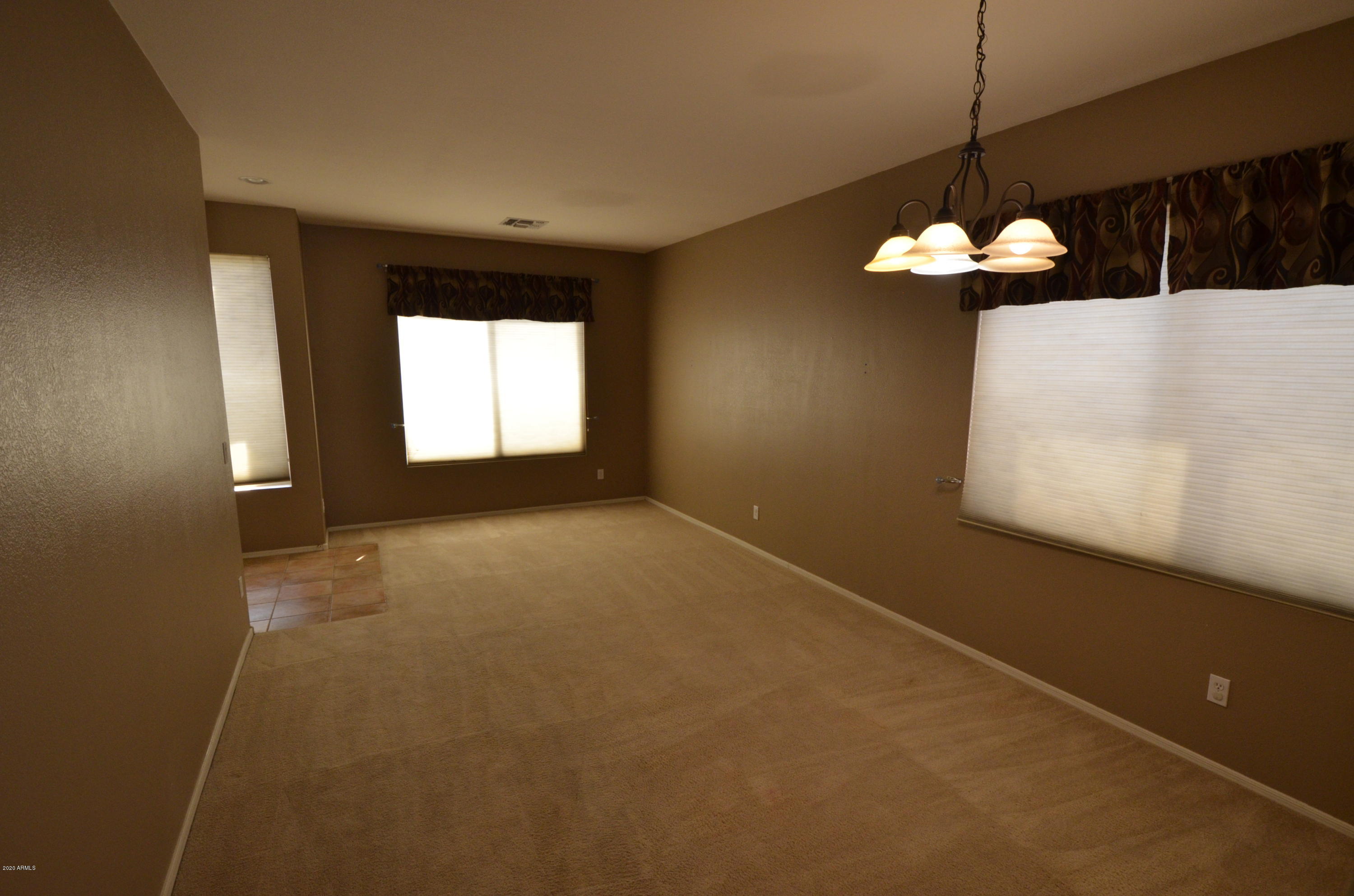 1148 South Roca Street Gilbert, AZ 85296 - Photo 3 of 20 a view of a room with a chandelier fan and fire place