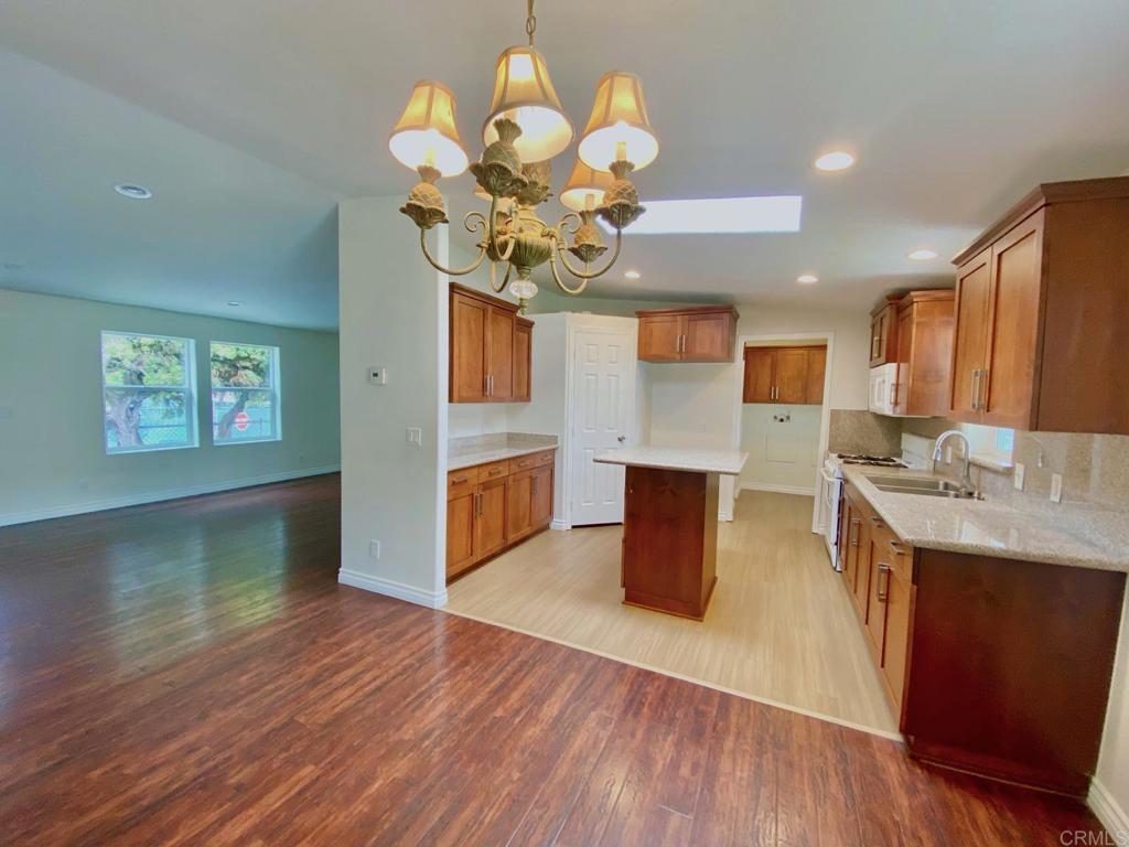 a kitchen with stainless steel appliances granite countertop a sink dishwasher a stove with wooden floor
