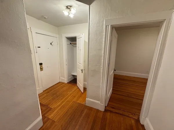 a view of a hallway with wooden floor and staircase