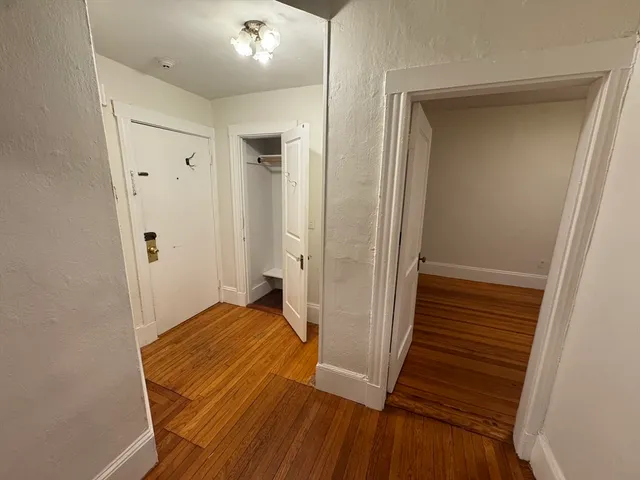 a view of a hallway with wooden floor and staircase