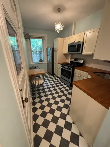 a kitchen with granite countertop stainless steel appliances a stove a sink and a refrigerator