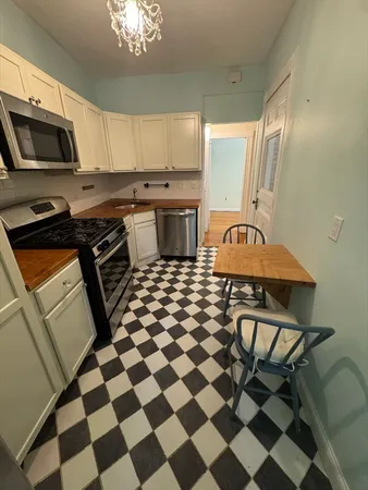 a kitchen with granite countertop stainless steel appliances a sink and a stove top oven