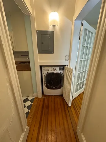 a view of a hallway with wooden floor and staircase
