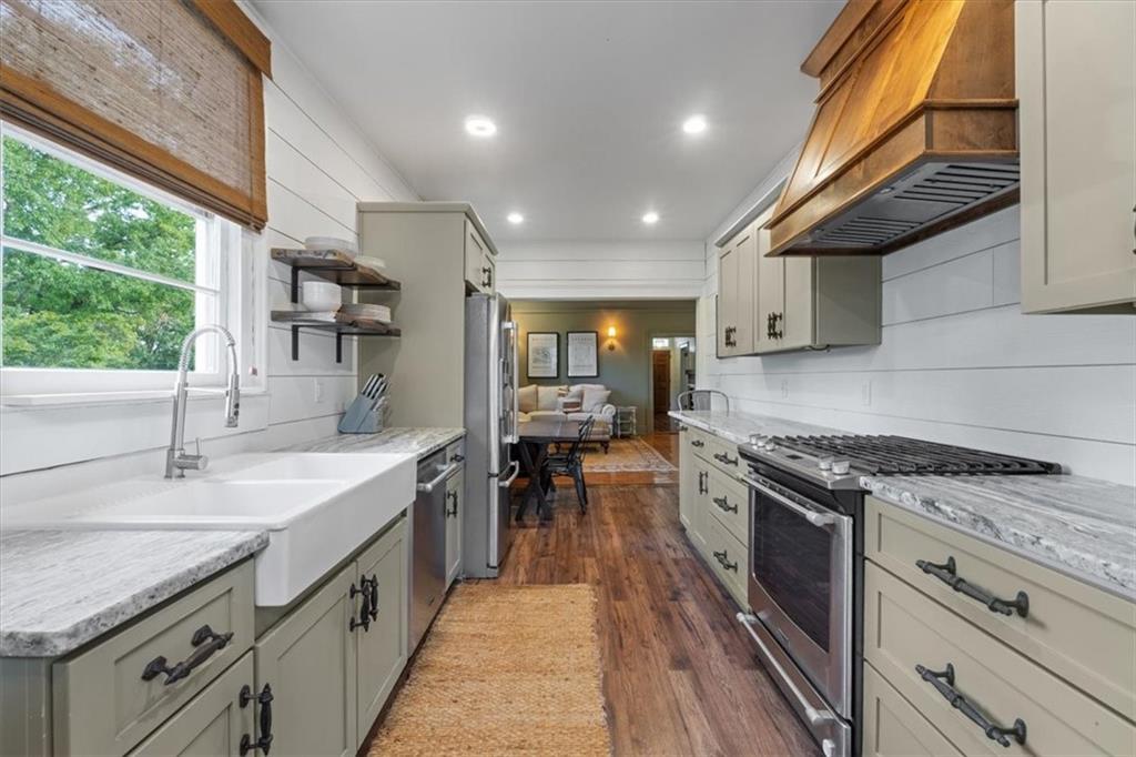 5143 Floyd Street Northeast Covington, GA 30014 - Photo 11 of 27 a kitchen with granite countertop a sink a counter top space stainless steel appliances and cabinets