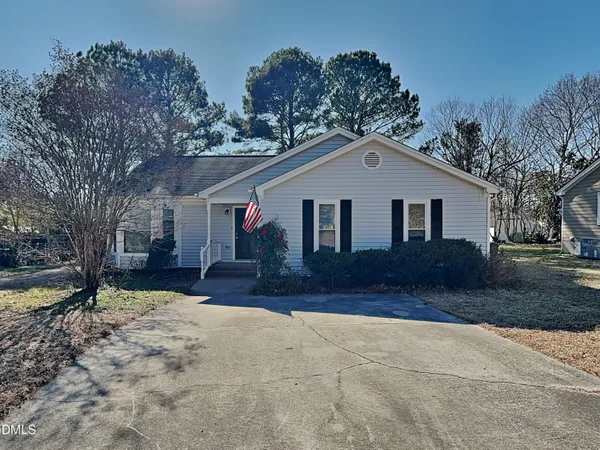 a front view of a house with a yard and trees