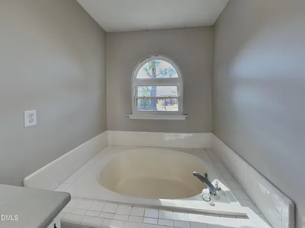 a white bath tub sitting in a bathroom next to a window