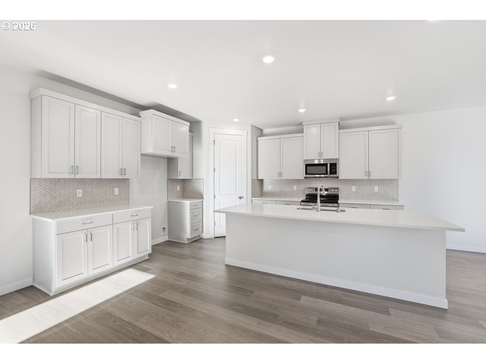 3201 Southwest 4th Avenue Battle Ground, WA 98604 - Photo 13 of 18 a kitchen with stainless steel appliances granite countertop a refrigerator sink and white cabinets