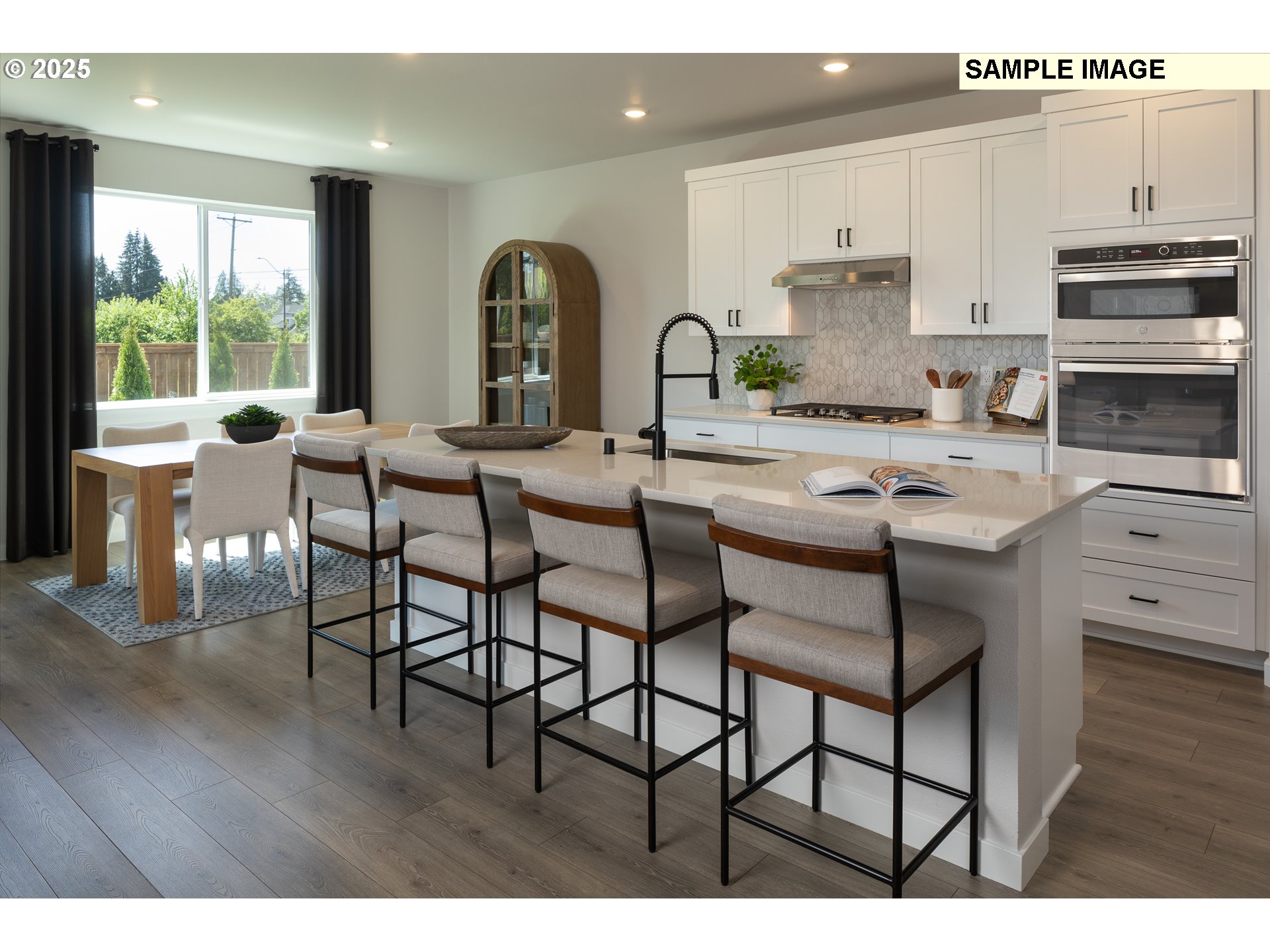 3201 Southwest 4th Avenue Battle Ground, WA 98604 - Photo 4 of 18 a kitchen with stainless steel appliances kitchen island a table chairs sink and cabinets