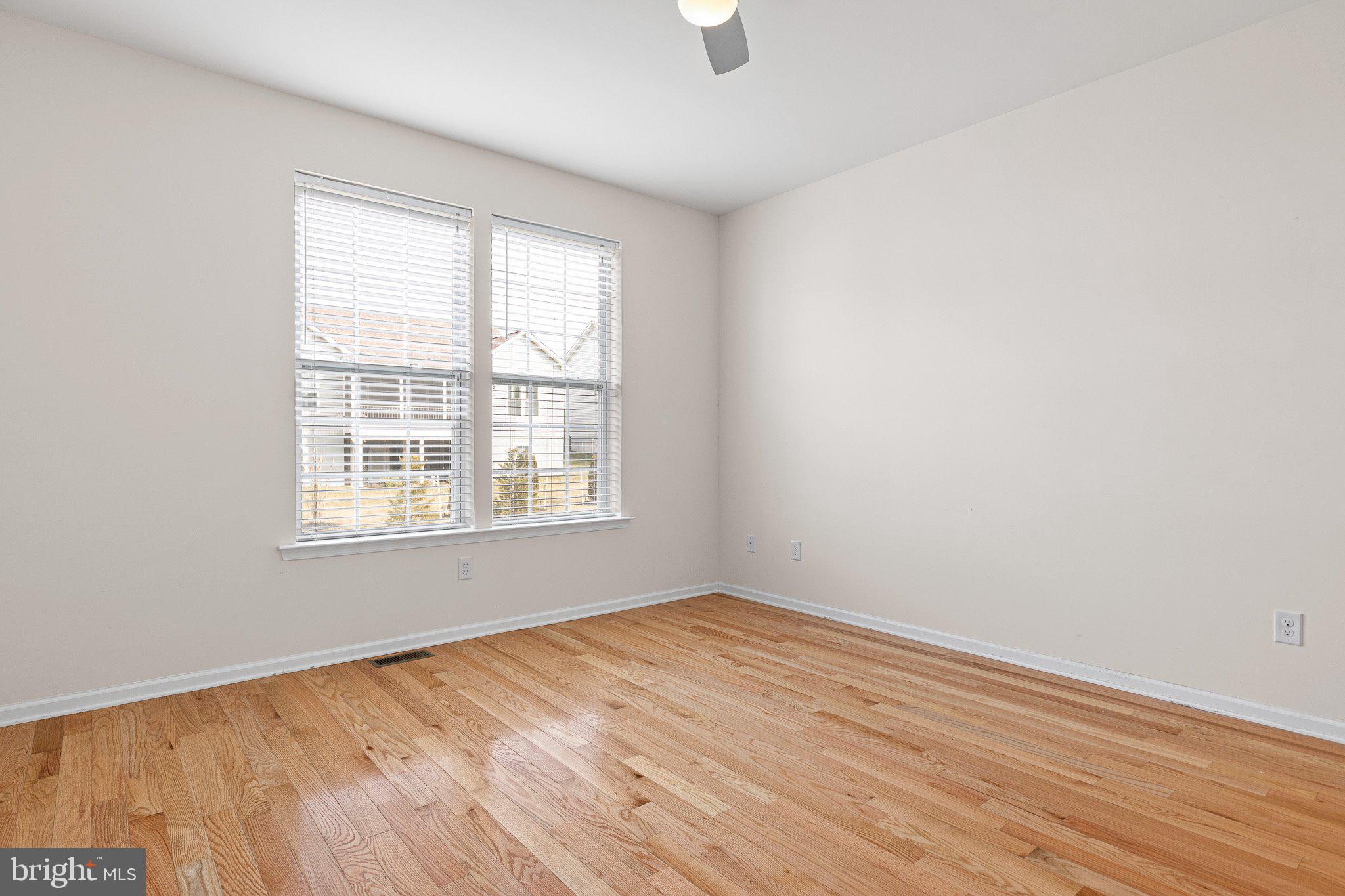 647 Vivaldi Drive Middletown, DE 19709 - Photo 9 of 38 an empty room with wooden floor and windows
