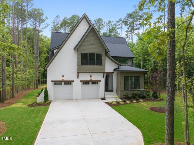 a front view of a house with a yard and trees