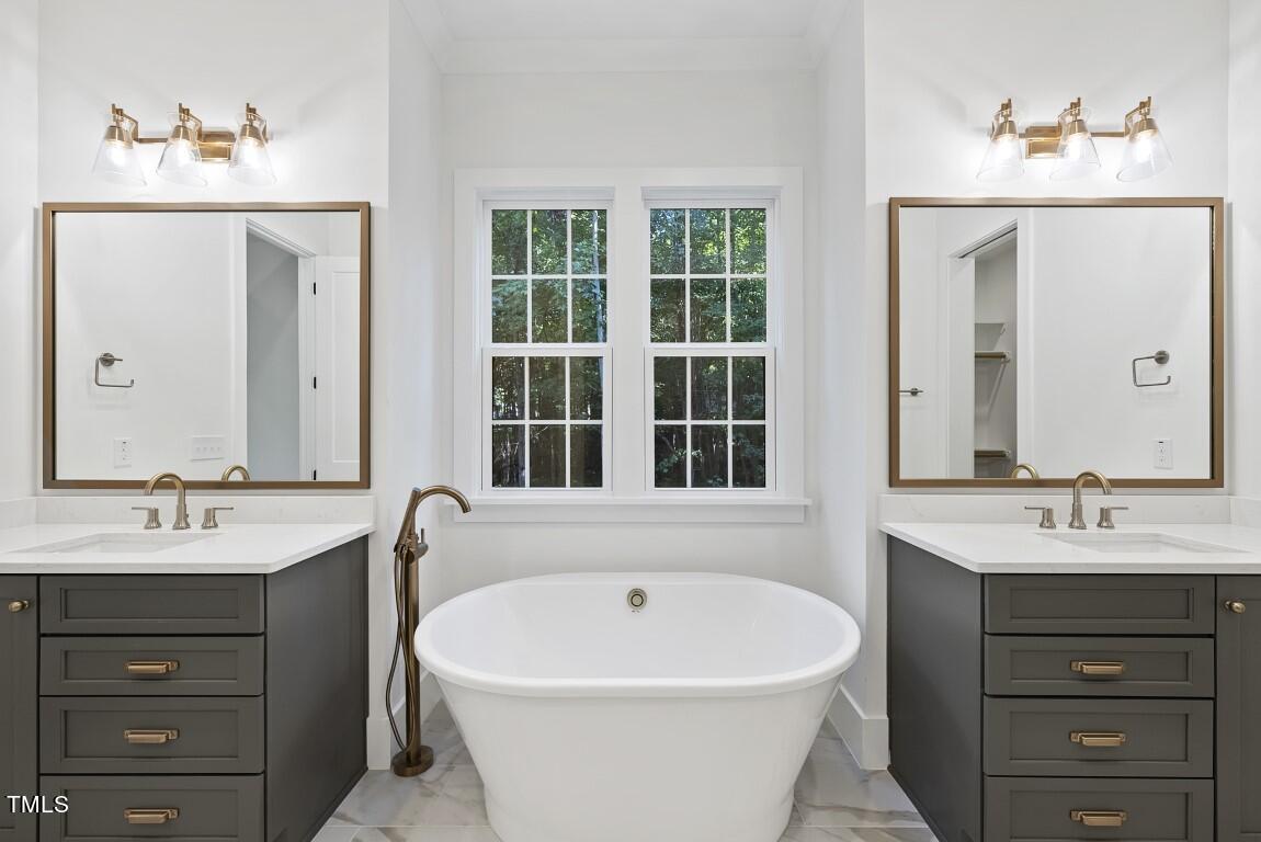 13541 Old Creedmoor Road Wake Forest, NC 27587 - Photo 14 of 41 a bathroom with a bathtub a sink a window and a mirror