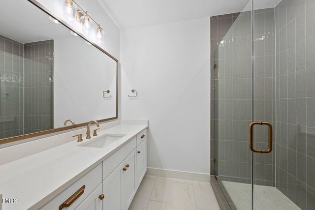 a bathroom with a double vanity sink a toilet and shower