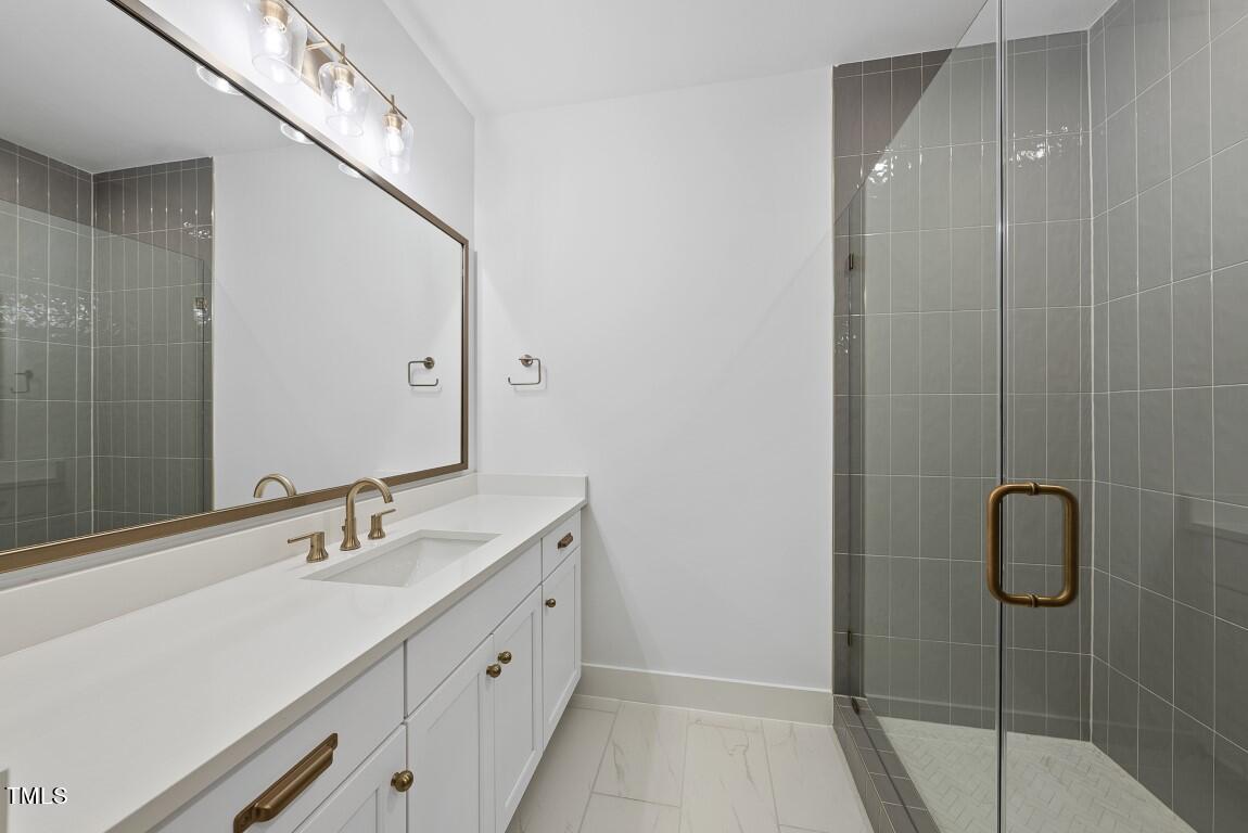 13541 Old Creedmoor Road Wake Forest, NC 27587 - Photo 20 of 41 a bathroom with a double vanity sink a toilet and shower