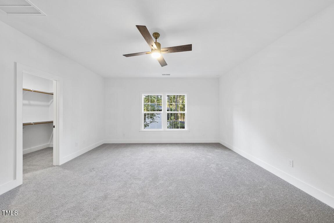 13541 Old Creedmoor Road Wake Forest, NC 27587 - Photo 22 of 41 an empty room with a window and a ceiling fan