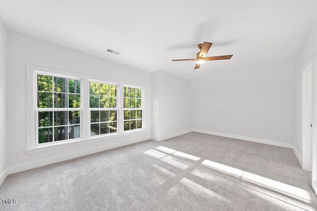 an empty room with a window and a ceiling fan